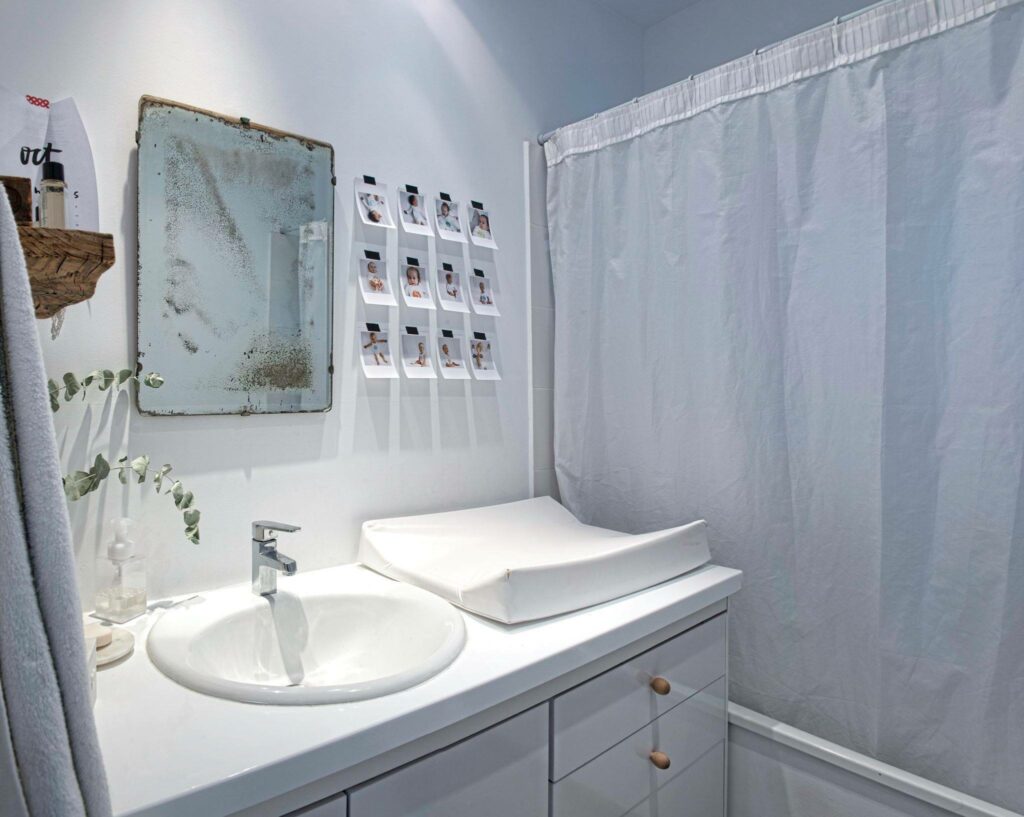 Bathroom with white walls and sink, and an old mirror