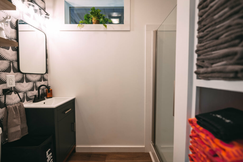 Bathroom sink with black cabinet and drawer, squircle mirror 