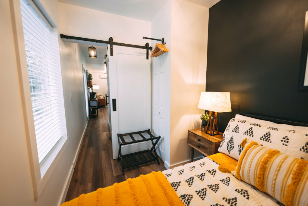 Bedroom with regular-sized bed, bedside table with lamp, and mini closet