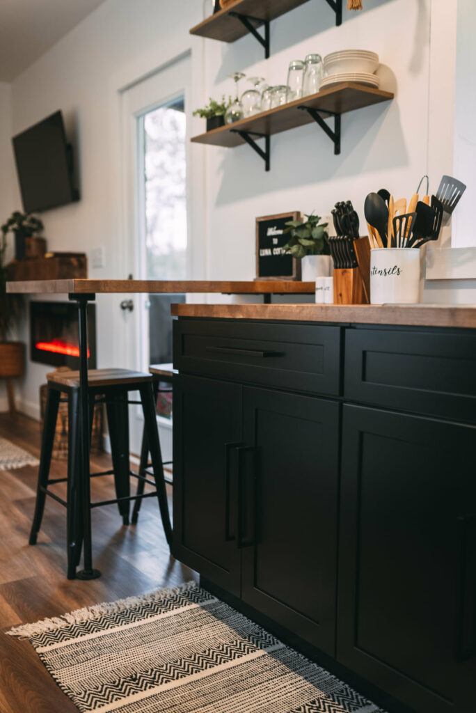 Kitchen countertop with utensils, black lower cabinets
