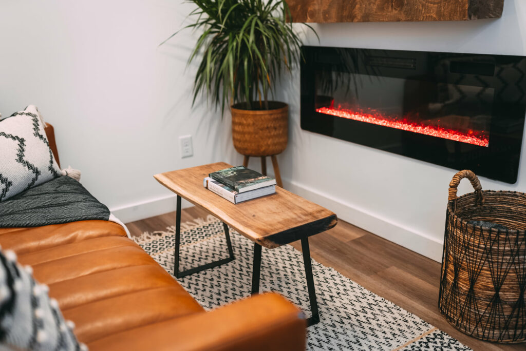 Living room leather couch, wooden center table, and electric fireplace