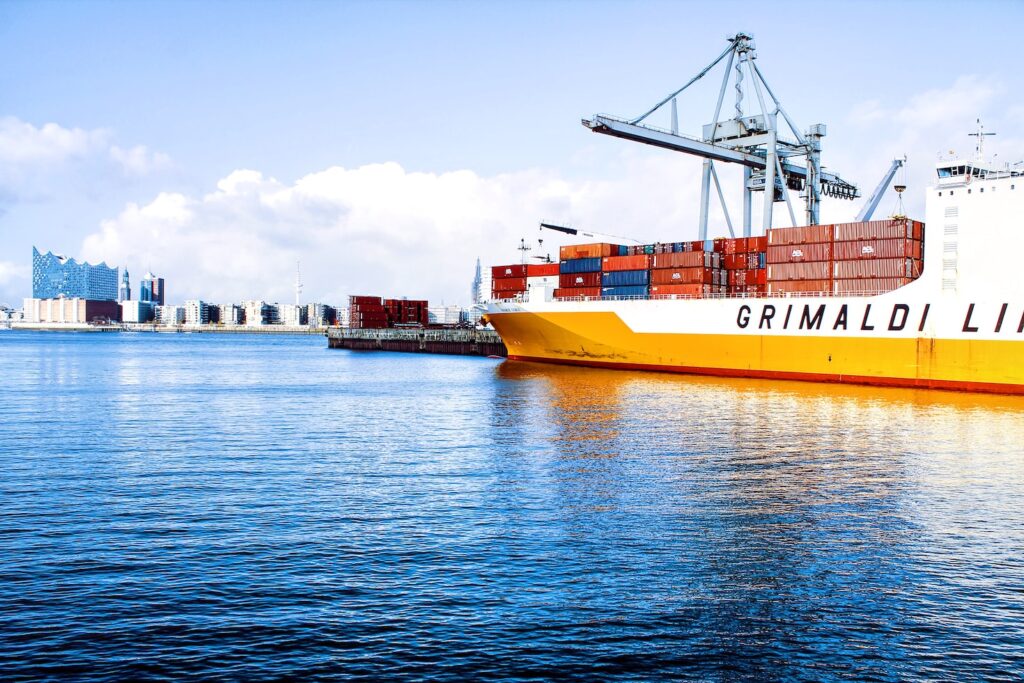 white and orange cargo ship with metal lifting equipment
