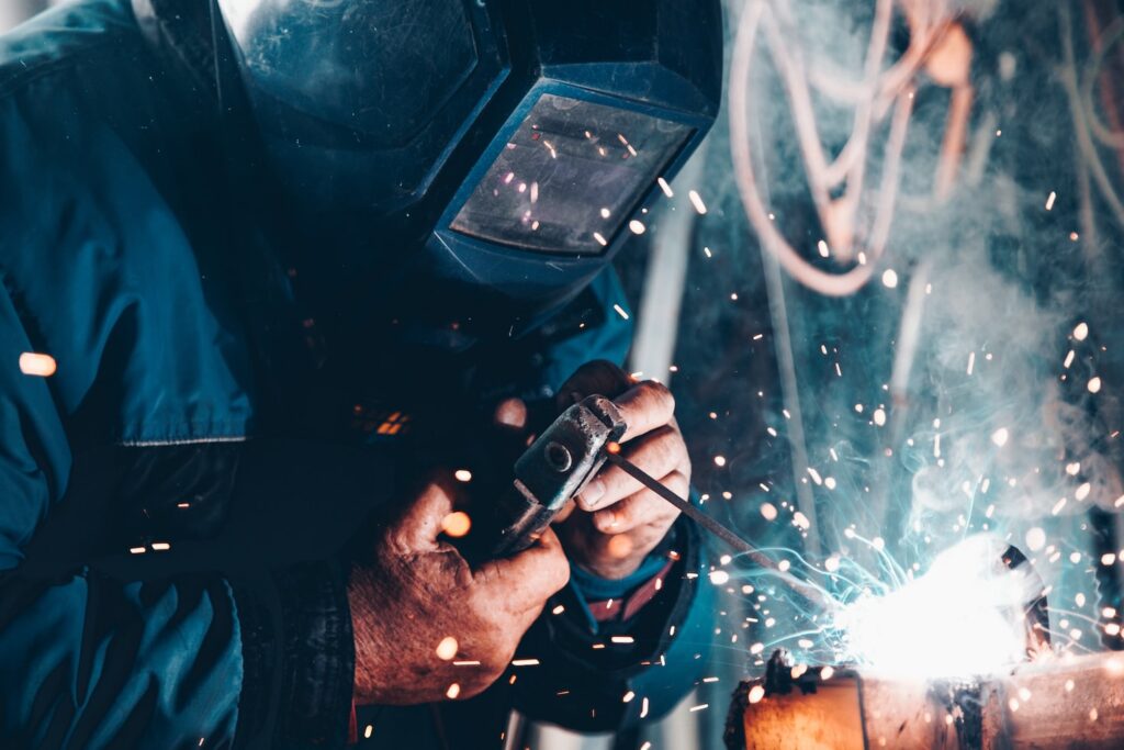 man using welding machine
