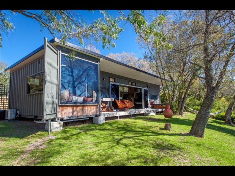 single storied container home beside a green lawn