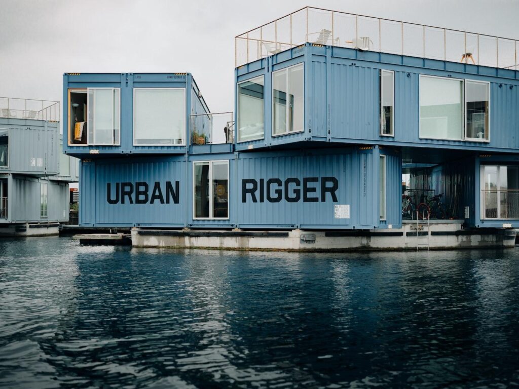 sky colored container home beside a small lake