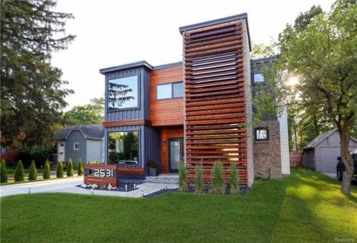 multi storied container home with a green yard in front